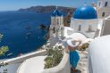 Oia Santorini Greece. Blue domes of Oia. Fashion model. Blue Dress. White Hat.